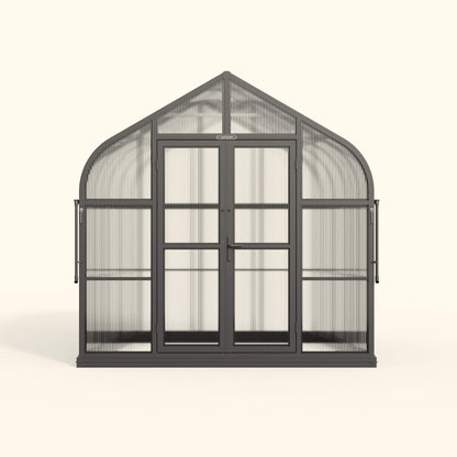 Exterior view of an 8.5 ft wide Pacific-style greenhouse with clear panels and a peaked roof in a backyard garden