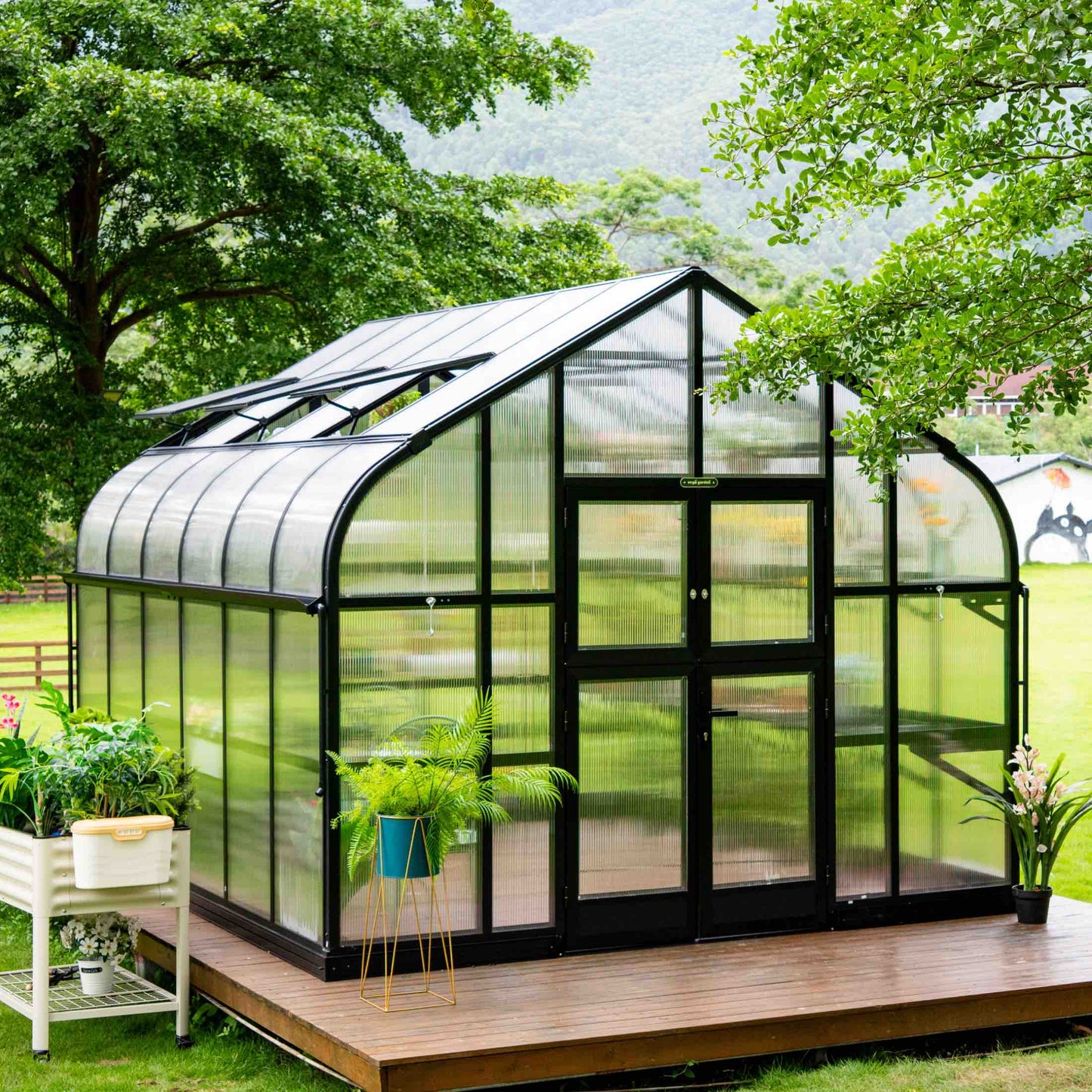 10.5 ft wide Pacific greenhouse in soft green with clear panels and double-door entrance under sunny sky
