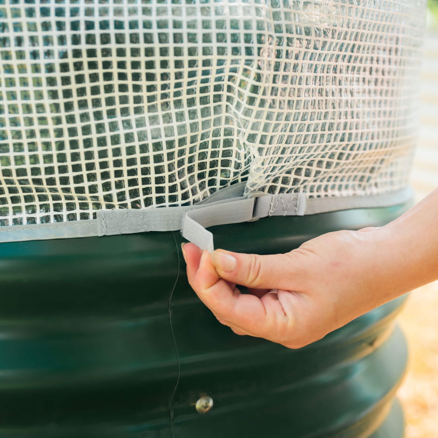 Frost protection cover with integrated trellis over garden plants, breathable fabric and support frame protecting leaves and stems