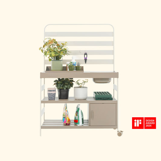 Outdoor wooden potting bench with shelves and work surface holding gardening tools and potted plants