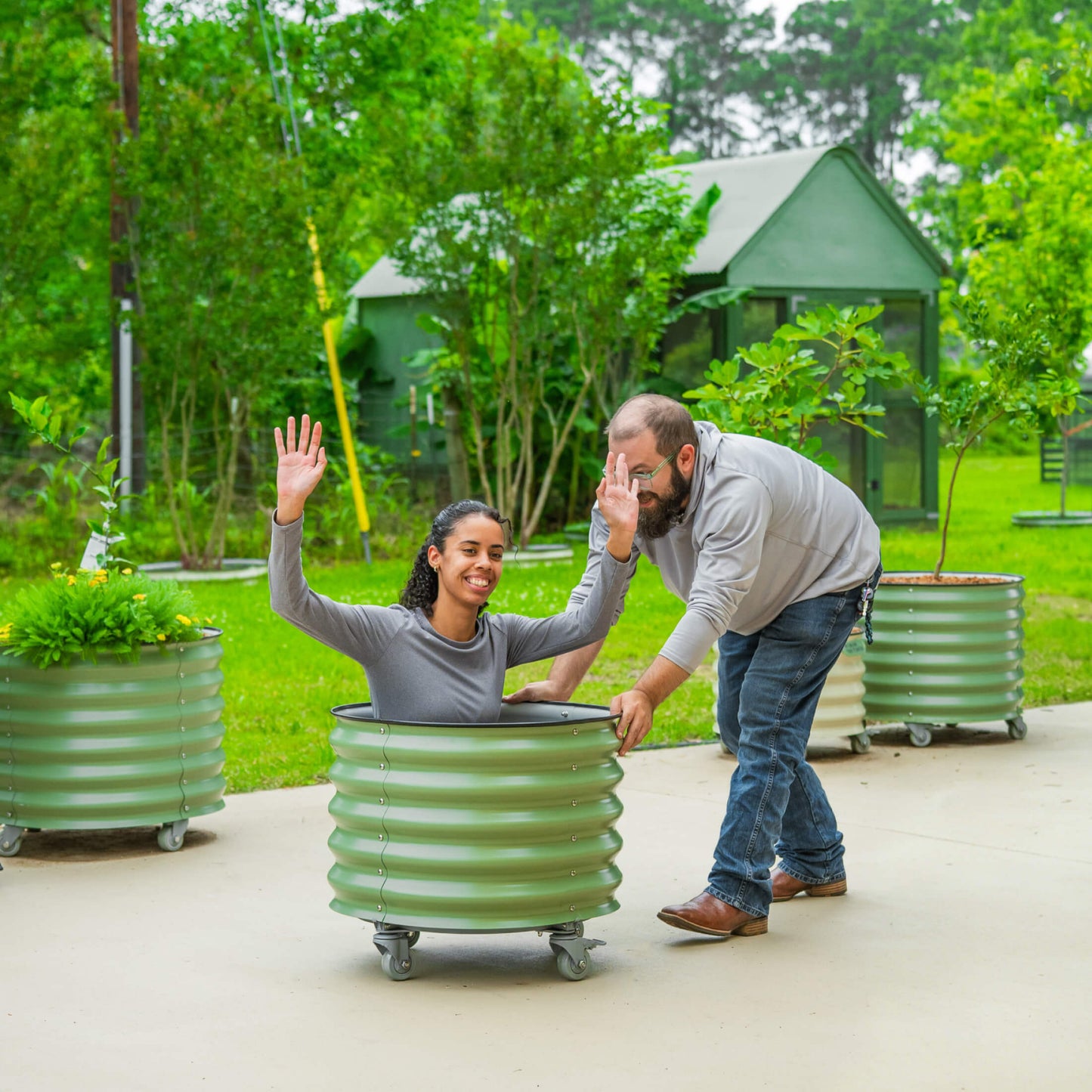 Large 30-gallon wheeled self-watering planter with trellis holding a mature citrus tree and lush green foliage