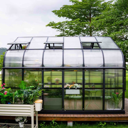 10.5 ft wide Pacific greenhouse with double-door entry and clear panels set on a backyard patio