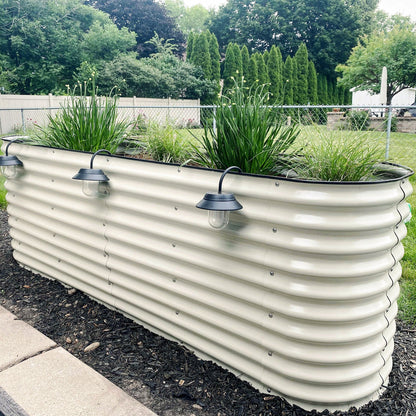 Extra-tall modular metal raised garden bed assembled outdoors with soil and seedlings, shown from angled side view