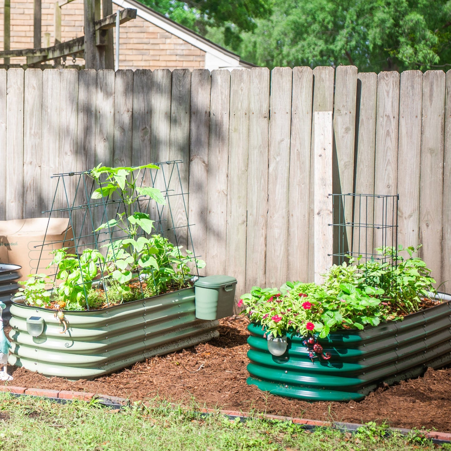 Three 6-tier metal tomato support towers stacked in a garden bed holding lush tomato plants