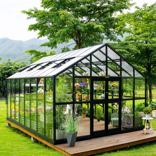 Large Victorian-style glass greenhouse with arched windows and double doors set on a gravel garden path