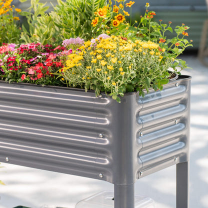Slim elevated wooden garden bed with soil and young herbs, 1.5' x 3.5', placed on patio decking