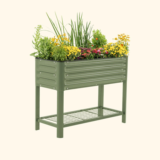 Slim elevated garden bed on legs filled with herbs and vegetables beside a patio